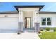 Inviting home entrance featuring a red front door framed by stone pillars and manicured landscaping at 482 Sunset N Rd, Rotonda West, FL 33947