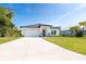 Attractive one-story house boasts a modern design, manicured lawn, and attached two-car garage at 482 Sunset N Rd, Rotonda West, FL 33947