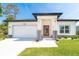 Charming single-story home with a well-manicured lawn, red front door, and two-car garage at 482 Sunset N Rd, Rotonda West, FL 33947