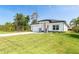 Charming single-story home with a lush green lawn, gray roof, and attached two-car garage at 482 Sunset N Rd, Rotonda West, FL 33947