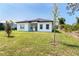Well-maintained home exterior with a spacious backyard, manicured lawn, and new landscaping for enhanced curb appeal at 482 Sunset N Rd, Rotonda West, FL 33947