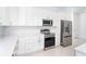 Gourmet kitchen with stainless steel appliances, white cabinets, and subway tile backsplash at 482 Sunset N Rd, Rotonda West, FL 33947