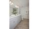 Bright bathroom showcasing a double sink vanity, wood-look tile floors, and neutral color scheme at 5009 Skyview Ln, Bradenton, FL 34211