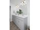 Bathroom featuring gray vanity with double sinks, white countertop, large mirror, and wood-look tile flooring at 5009 Skyview Ln, Bradenton, FL 34211