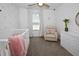 Cozy Bedroom showcasing a white crib, recliner, pink blanket, and palm tree wall decals at 5009 Skyview Ln, Bradenton, FL 34211