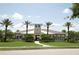 Clubhouse with palm trees, landscaped grounds, sidewalk, street, and blue skies in the Harmony community at 5009 Skyview Ln, Bradenton, FL 34211