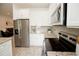 Well-lit modern kitchen featuring stainless steel refrigerator, oven, and microwave with white cabinets at 5009 Skyview Ln, Bradenton, FL 34211