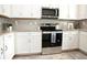Modern kitchen showcasing stainless steel oven, microwave, and white cabinets with granite countertops at 5009 Skyview Ln, Bradenton, FL 34211