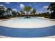 Large resort style pool with blue tile, palm trees, lounge chairs, and clubhouse in the Harmony community at 5009 Skyview Ln, Bradenton, FL 34211