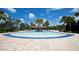Large resort style pool with blue tile, palm trees, lounge chairs, and clubhouse in the Harmony community at 5009 Skyview Ln, Bradenton, FL 34211