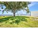 Serene backyard featuring lush green grass, shade trees and outdoor furniture overlooking the water at 5174 Conner Ter, Port Charlotte, FL 33981