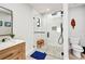 White bathroom with a single sink wooden vanity, mirror, toilet and a walk-in glass shower at 5174 Conner Ter, Port Charlotte, FL 33981