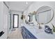 Well-lit bathroom featuring a long blue vanity with double sinks, two round mirrors and a glass shower at 5174 Conner Ter, Port Charlotte, FL 33981