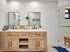 Bright bathroom featuring a double sink wooden vanity, two mirrors and a walk-in glass shower at 5174 Conner Ter, Port Charlotte, FL 33981