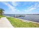 Dock on the water with lush green grass and sidewalk at 5174 Conner Ter, Port Charlotte, FL 33981