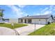 Inviting waterfront home featuring a well-manicured lawn, attached garage, and stylish modern exterior at 5174 Conner Ter, Port Charlotte, FL 33981