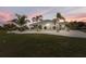 Spacious backyard featuring a covered patio, lush landscaping, and serene sunset views at 530 Spaniards Rd, Placida, FL 33946