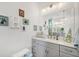 Bright bathroom featuring gray vanity cabinets, a large mirror, and decorative touches at 530 Spaniards Rd, Placida, FL 33946