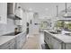 Open-concept kitchen with modern appliances, gray cabinets, and easy access to the outdoor patio at 530 Spaniards Rd, Placida, FL 33946