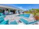 Beautiful blue in-ground pool with patio seating, outdoor bar, and landscaping at 530 Spaniards Rd, Placida, FL 33946