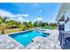 Enjoy the Florida sunshine by the pool in this backyard featuring comfortable seating and lush landscaping at 530 Spaniards Rd, Placida, FL 33946