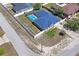Stunning aerial view of a home with a sparkling screened-in pool and fenced-in backyard at 5510 Moongate Rd, Spring Hill, FL 34606
