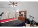Well-lit bedroom featuring a ceiling fan, dresser, exercise bike, and doorway to other rooms at 5510 Moongate Rd, Spring Hill, FL 34606