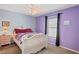 Bedroom with purple walls, a white bed, nightstand, a ceiling fan, a window, and neutral colored carpeting at 5510 Moongate Rd, Spring Hill, FL 34606