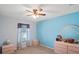 Bedroom with light blue walls, a ceiling fan, a window, two dressers, and neutral colored carpeting at 5510 Moongate Rd, Spring Hill, FL 34606