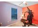 Bedroom with gym equipment, a window, and contrasting orange and purple walls at 5510 Moongate Rd, Spring Hill, FL 34606