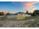 Back exterior view of the home at sunset with an illuminated fenced yard at 5510 Moongate Rd, Spring Hill, FL 34606