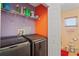 Efficient laundry room with modern washer and dryer, storage shelf, plus attached bath at 5510 Moongate Rd, Spring Hill, FL 34606