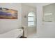 Bright bathroom with subway tile, soaking tub, rainfall shower head, and arched window at 59 White Marsh Ln, Rotonda West, FL 33947