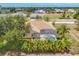 Exterior of the home featuring a screened-in pool and tropical landscaping at 59 White Marsh Ln, Rotonda West, FL 33947