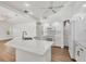 Modern kitchen featuring white cabinets, stainless steel appliances, a quartz island, and wood floors at 59 White Marsh Ln, Rotonda West, FL 33947