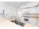 This bright kitchen features a double sink and all white appliances at 6158 Cavan St, Englewood, FL 34224