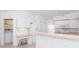 Bright kitchen with all white cabinets, appliances, eat-in counter, and desk area at 6158 Cavan St, Englewood, FL 34224