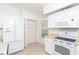 Open white kitchen featuring matching appliances and lots of cabinet space at 6158 Cavan St, Englewood, FL 34224