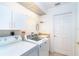 Laundry room with a washing machine, dryer, cabinets, and utility sink for added convenience at 6158 Cavan St, Englewood, FL 34224