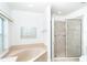 Main bathroom featuring large soaking tub, glass-enclosed shower, and lots of light at 6158 Cavan St, Englewood, FL 34224