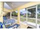 Enclosed patio with seating area, bright paint, and yard views through windows at 6158 Cavan St, Englewood, FL 34224