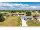 Aerial view of a well-maintained home on a large lot with mature trees and a long driveway at 7048 Inland St, Englewood, FL 34224