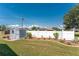 Large backyard features a storage shed, lush green grass, and a white privacy fence creating a private outdoor space at 7048 Inland St, Englewood, FL 34224
