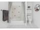 Bright bathroom featuring shower-tub combo with tiled walls, decorative accents, and built-in storage at 7048 Inland St, Englewood, FL 34224