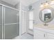 Well-lit bathroom featuring a glass-enclosed shower, vanity with marble countertop, and outdoor access at 7048 Inland St, Englewood, FL 34224