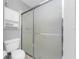 Clean bathroom featuring a glass shower enclosure, toilet, and storage, designed for comfort and convenience at 7048 Inland St, Englewood, FL 34224