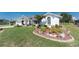Inviting home featuring lush landscaping, decorative rocks, and a beautifully maintained lawn at 7048 Inland St, Englewood, FL 34224