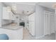 Well-lit kitchen showcasing white appliances, cabinets, tile floors, and an open layout to the dining area at 7048 Inland St, Englewood, FL 34224