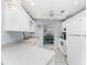 Airy kitchen with white appliances and cabinetry, complemented by a clear view into the dining space at 7048 Inland St, Englewood, FL 34224