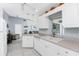 Bright kitchen featuring white cabinets, tile flooring, and natural light with a view to the living room at 7048 Inland St, Englewood, FL 34224